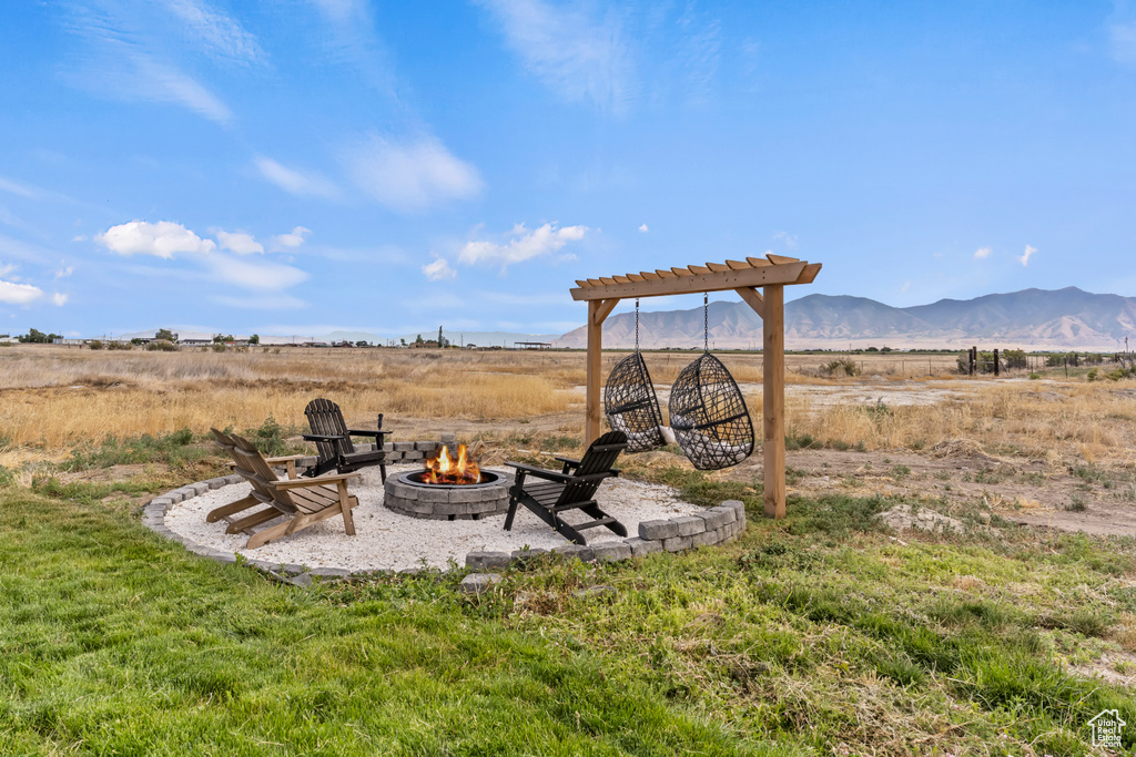 View of yard featuring a fire pit, a mountain view, a pergola, and a view of countryside