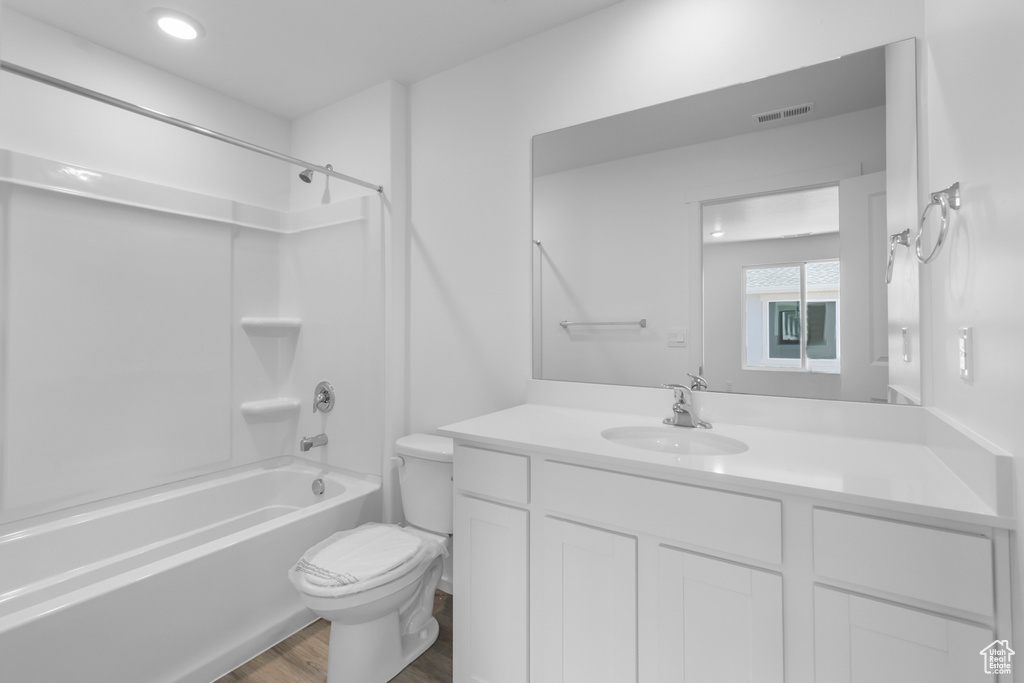 Bathroom with vanity, shower / tub combination, and wood finished floors