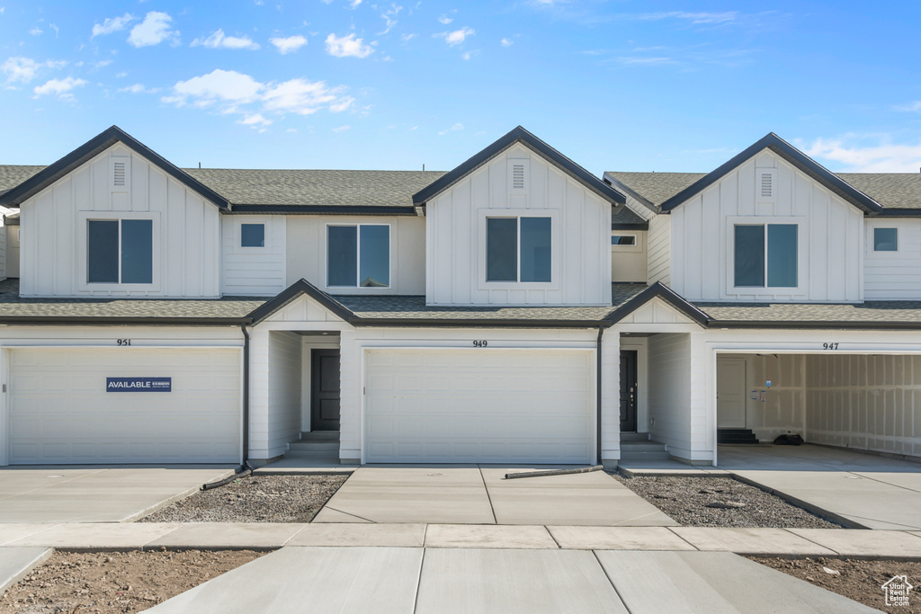 Townhome / multi-family property featuring board and batten siding, a garage, and a shingled roof