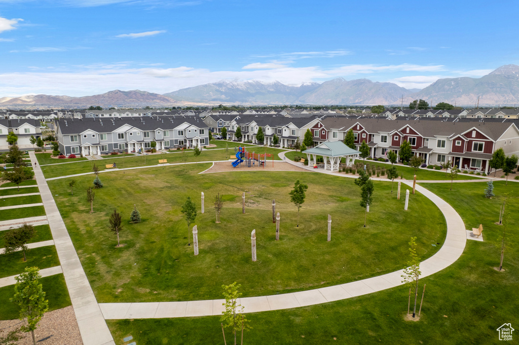 Aerial view of residential area featuring a community park and a mountainous background