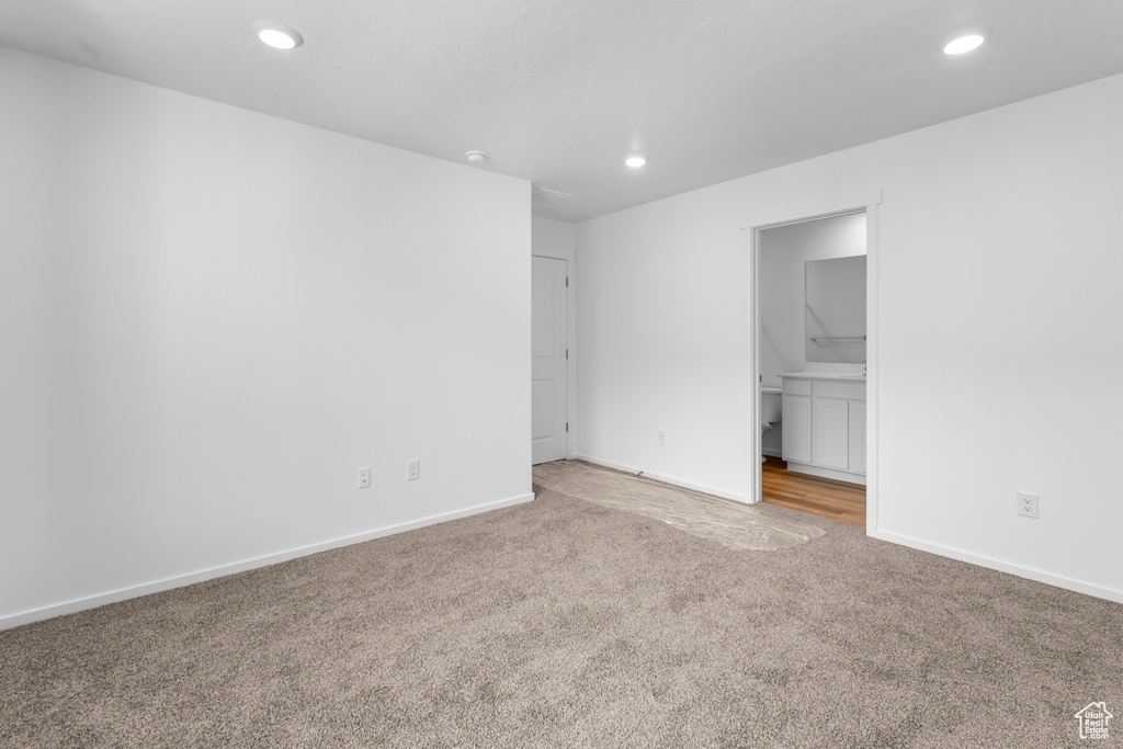 Unfurnished bedroom featuring light colored carpet, recessed lighting, and ensuite bath