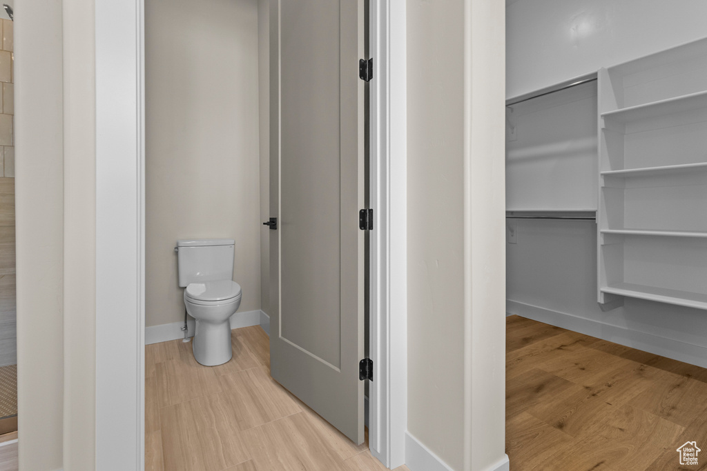 Full bathroom with toilet and wood finished floors