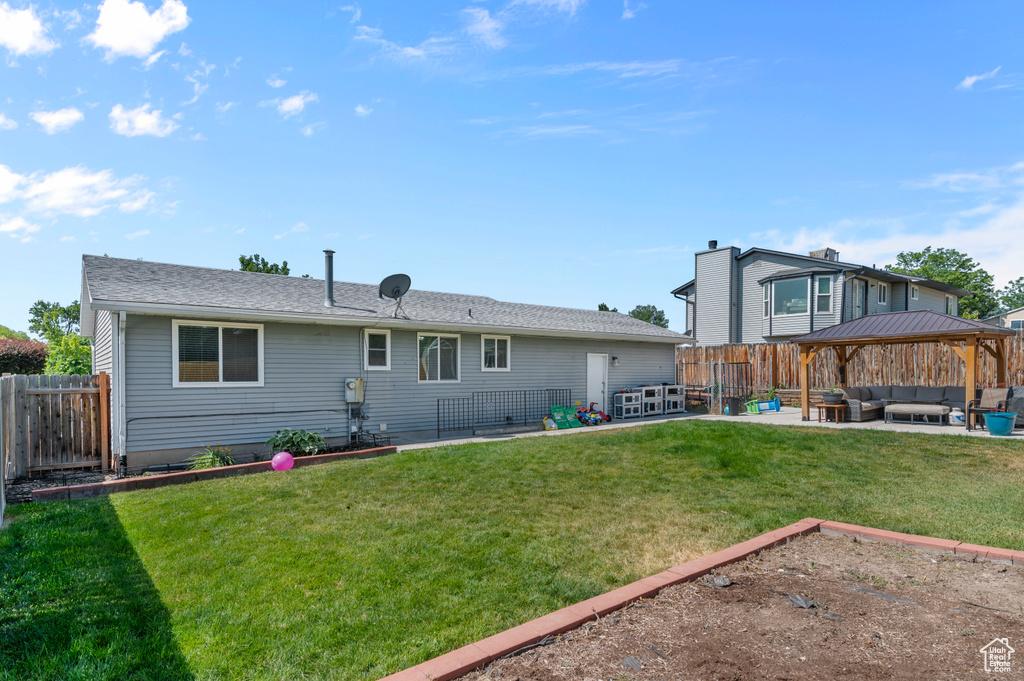 Rear view of house featuring an outdoor hangout area, a gazebo, a patio area, and a fenced backyard