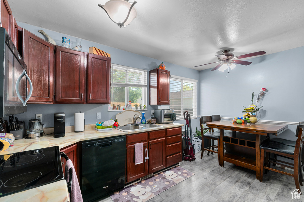 Kitchen featuring black appliances, light countertops, reddish brown cabinets, ceiling fan, and light wood-style floors