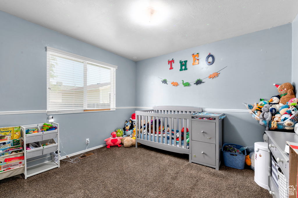 Carpeted bedroom featuring a crib