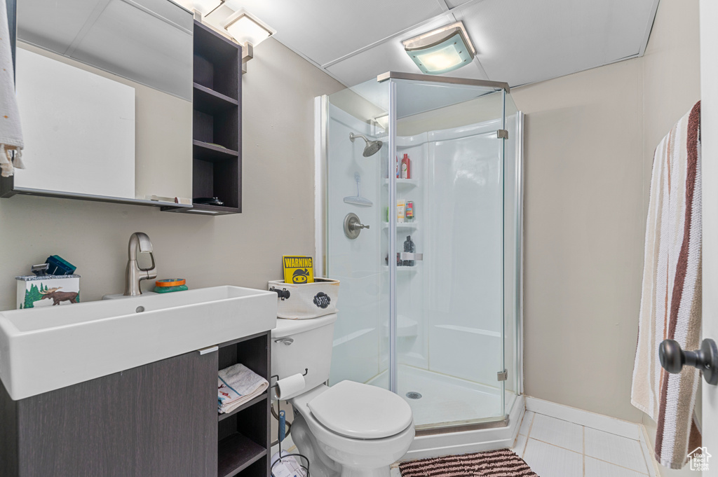 Full bath with a shower stall, tile patterned floors, and vanity