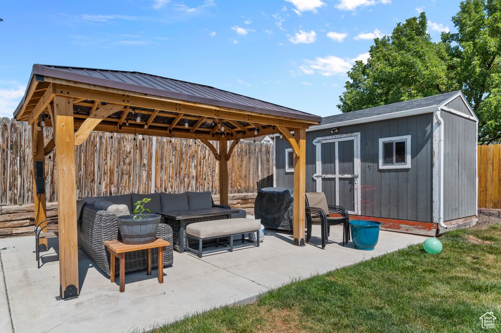 Fenced backyard featuring a gazebo, a patio, a storage shed, an outdoor hangout area, and grilling area