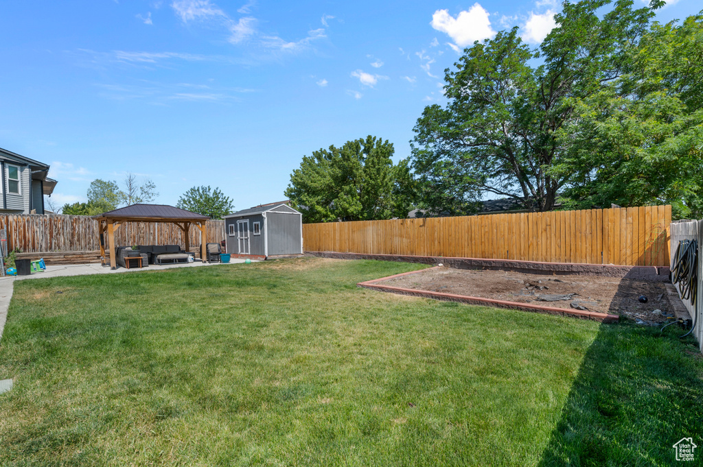 Fenced backyard with an outdoor hangout area, a gazebo, a storage shed, and a patio area