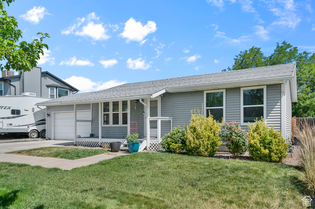 Ranch-style home featuring a garage, a front yard, concrete driveway, and roof with shingles