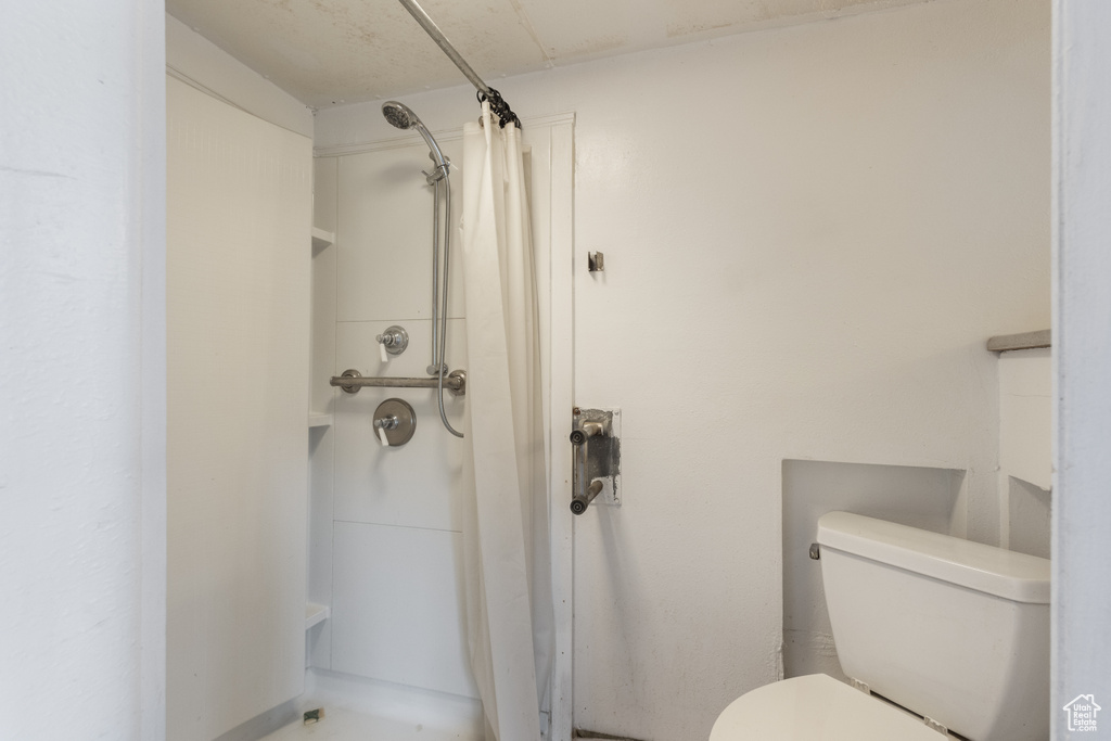 Full bathroom with a shower with shower curtain and toilet