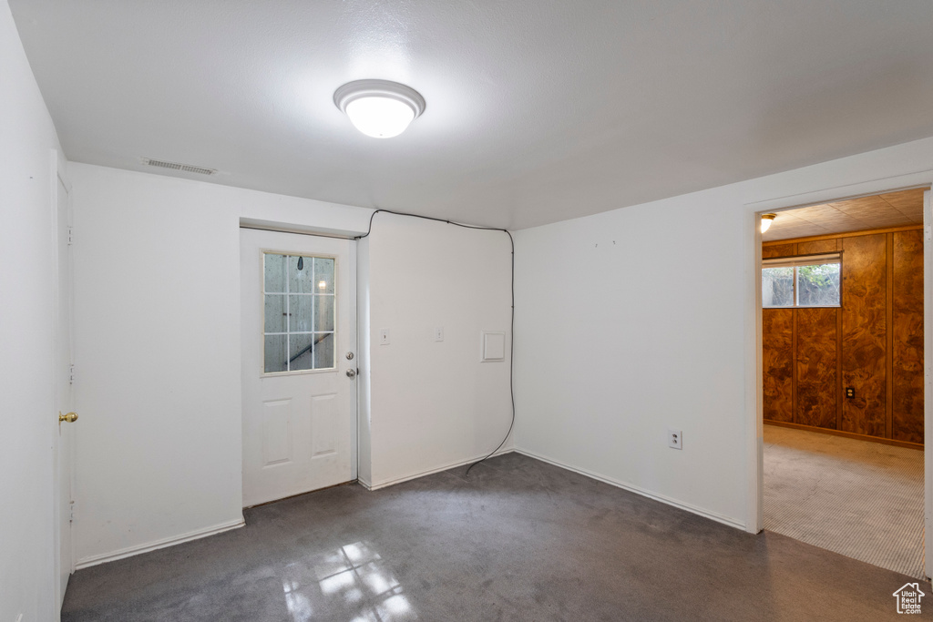 Unfurnished room featuring baseboards and wooden walls