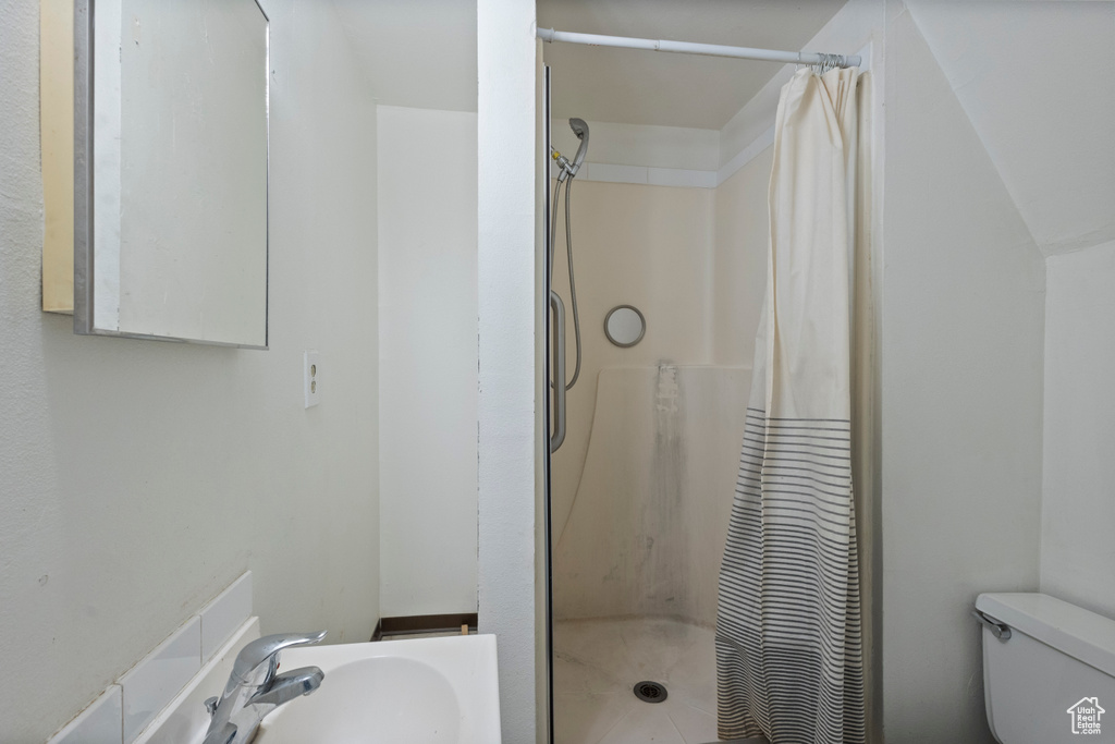 Bathroom with toilet and a shower with shower curtain