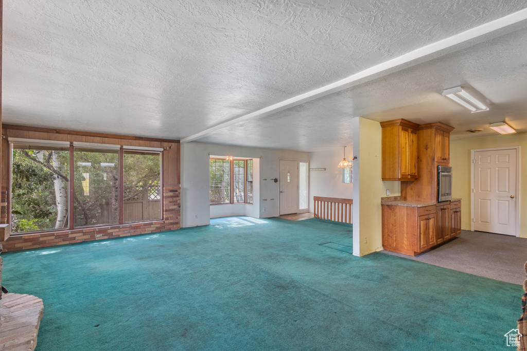 Unfurnished living room with carpet and a textured ceiling