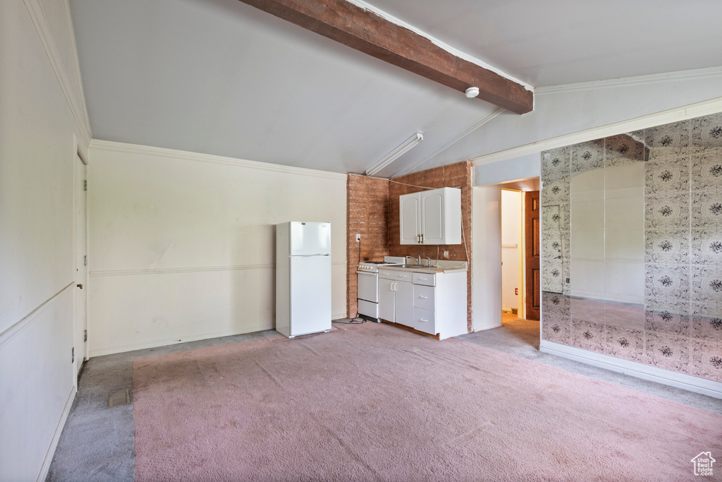 Kitchen featuring white appliances, light carpet, light countertops, and white cabinetry
