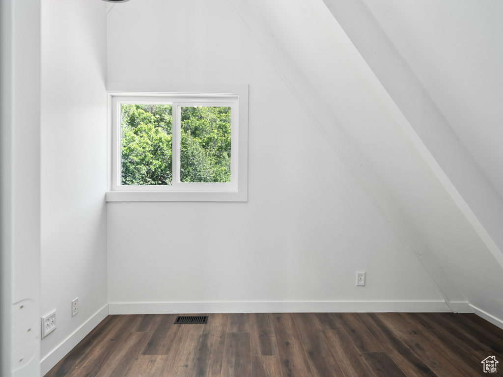 Additional living space with vaulted ceiling and dark wood-style floors