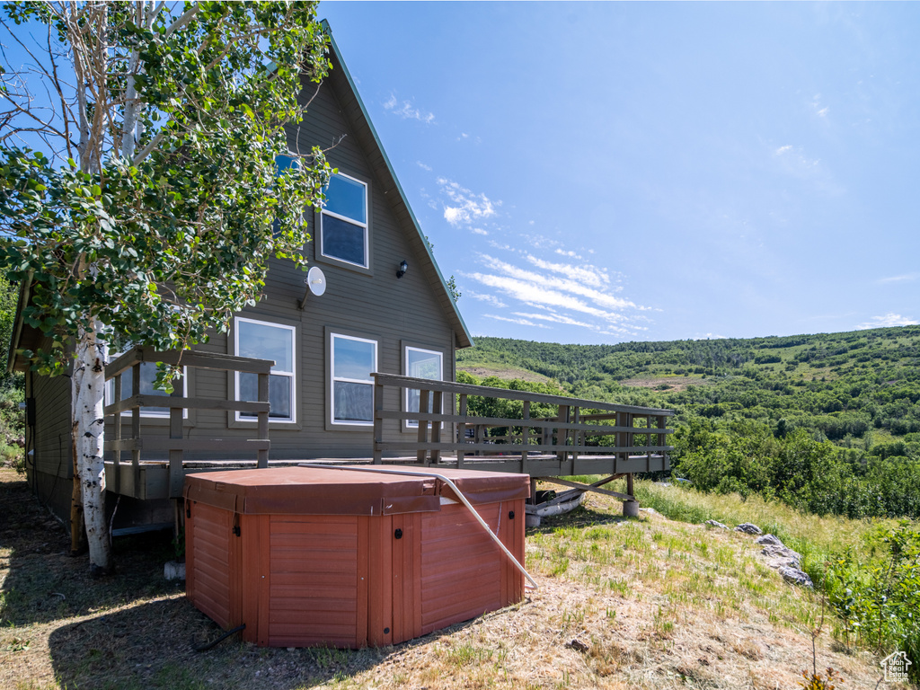 Rear view of house with a hot tub and a deck