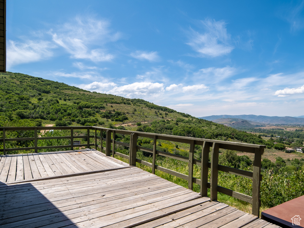 Wooden deck with a mountain view and a wooded view