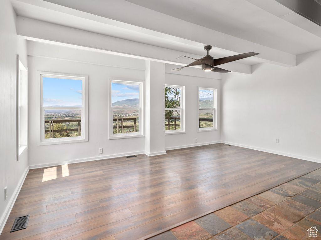 Unfurnished living room with a ceiling fan and dark wood-style flooring