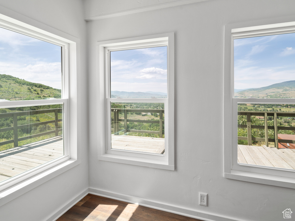 Unfurnished room with a mountain view and dark wood finished floors