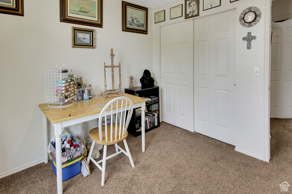 Carpeted home office featuring baseboards