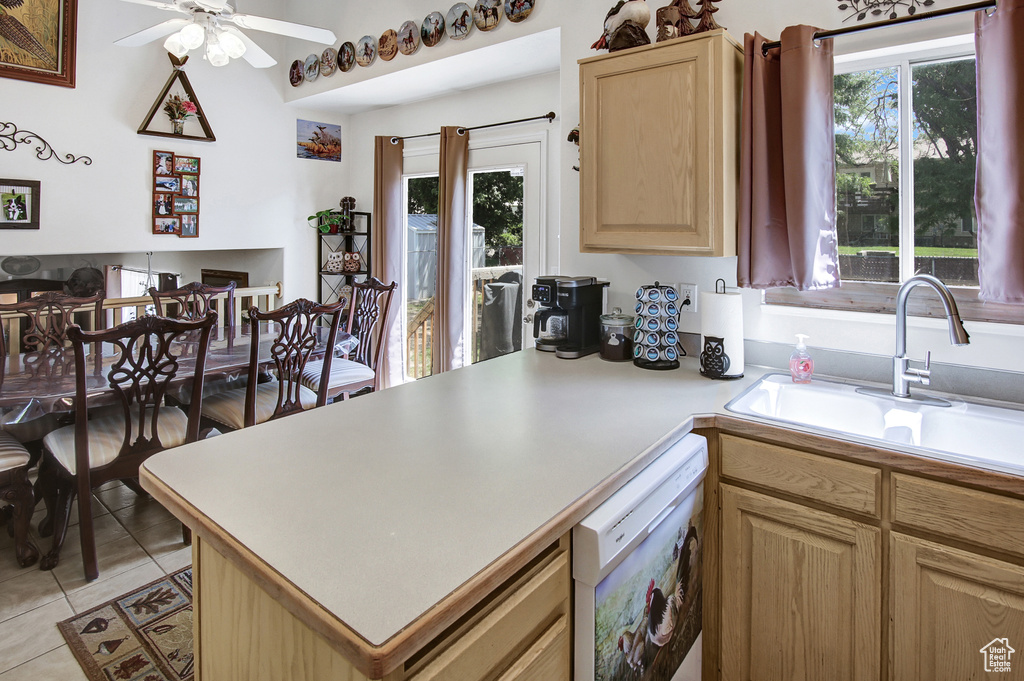 Kitchen with light brown cabinets, white dishwasher, ceiling fan, light countertops, and light tile patterned floors