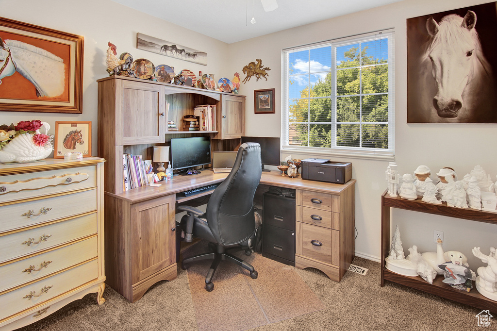 Home office featuring light carpet and a ceiling fan