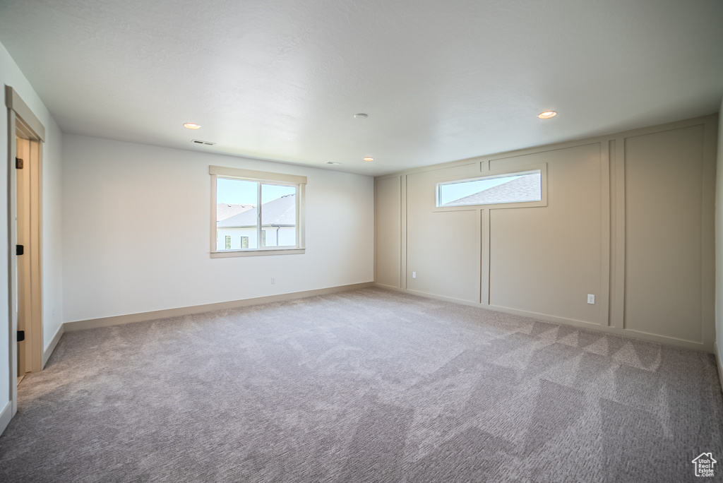 Spare room with healthy amount of natural light, light colored carpet, and recessed lighting