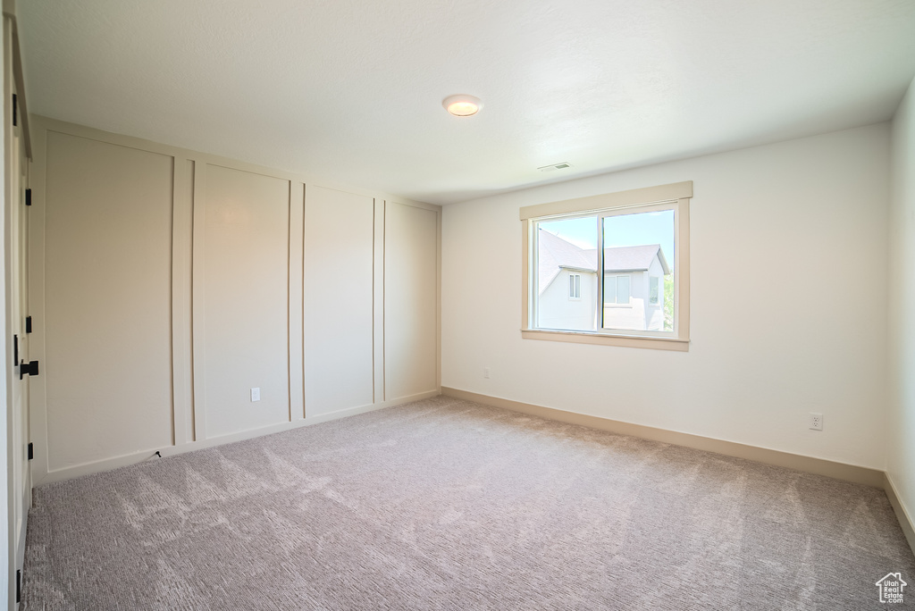 Spare room featuring light carpet