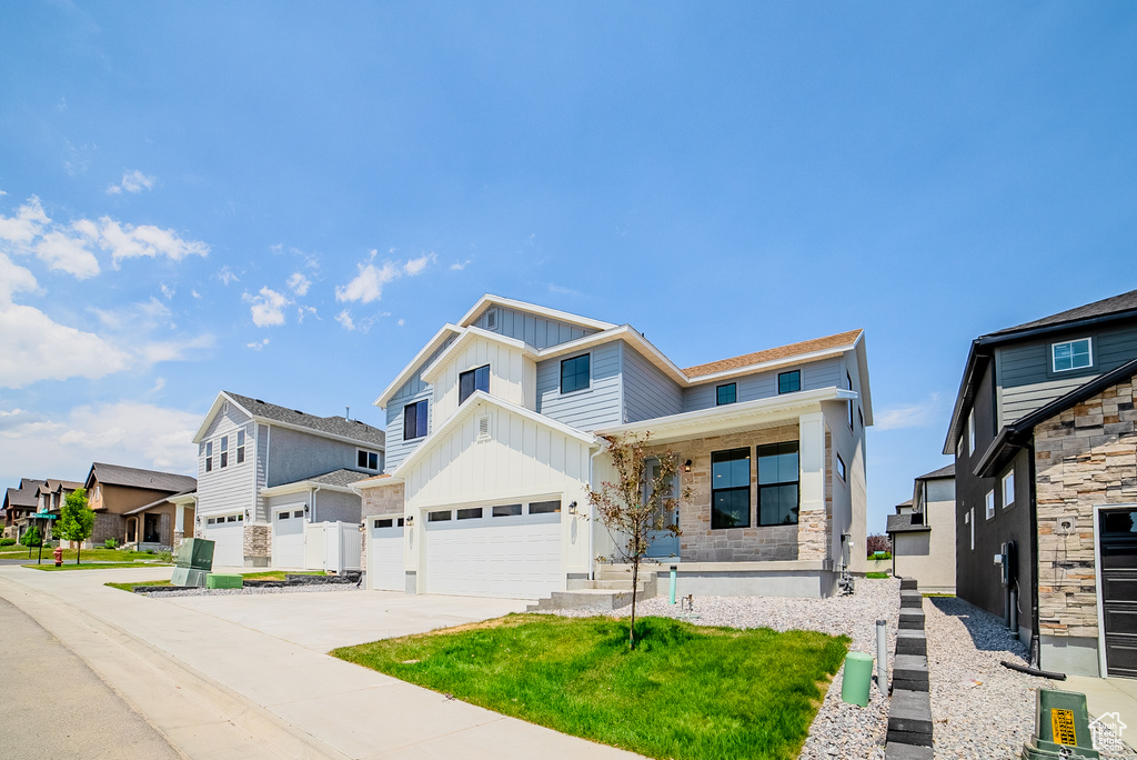 View of front of home featuring board and batten siding, a residential view, a porch, concrete driveway, and a garage
