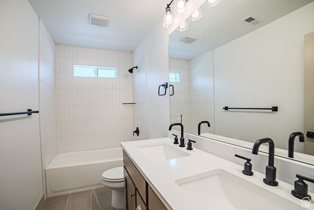 Bathroom featuring double vanity, tile patterned flooring, and shower / bathtub combination