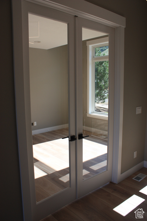 Doorway to outside with wood finished floors and baseboards