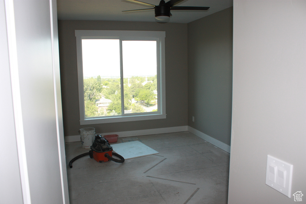 Unfurnished room featuring concrete flooring and ceiling fan