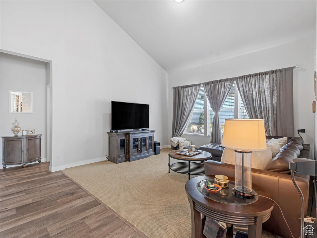 Living area featuring high vaulted ceiling and wood finished floors