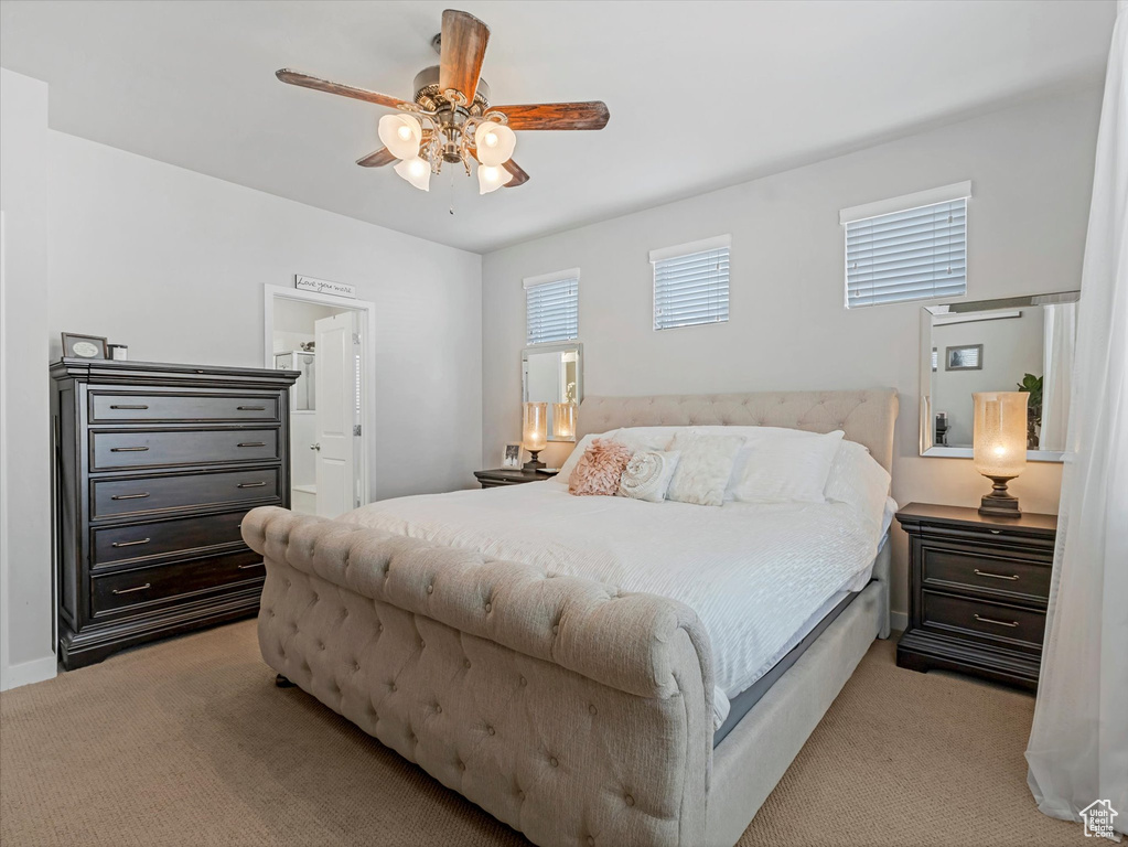 Bedroom featuring light colored carpet, a ceiling fan, and ensuite bathroom