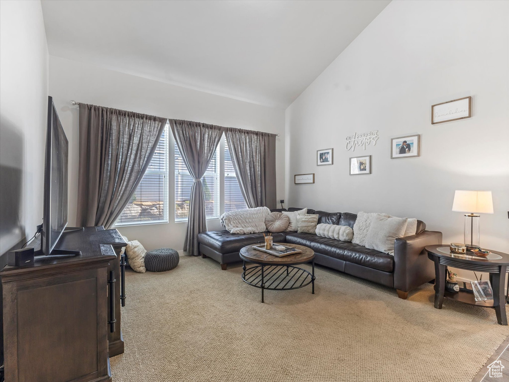 Carpeted living area with high vaulted ceiling