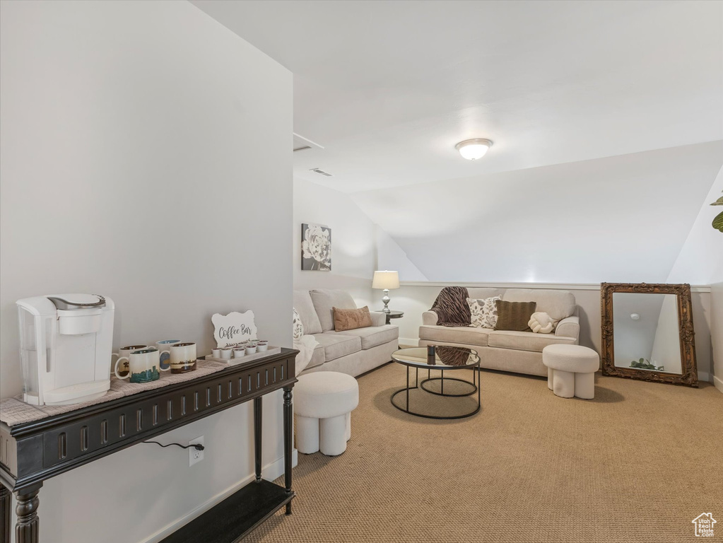 Living area featuring lofted ceiling and carpet flooring