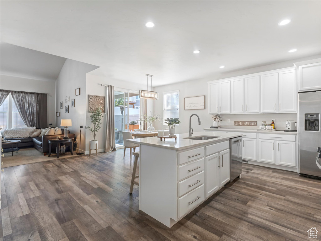 Kitchen featuring stainless steel appliances, light countertops, dark wood finished floors, and recessed lighting
