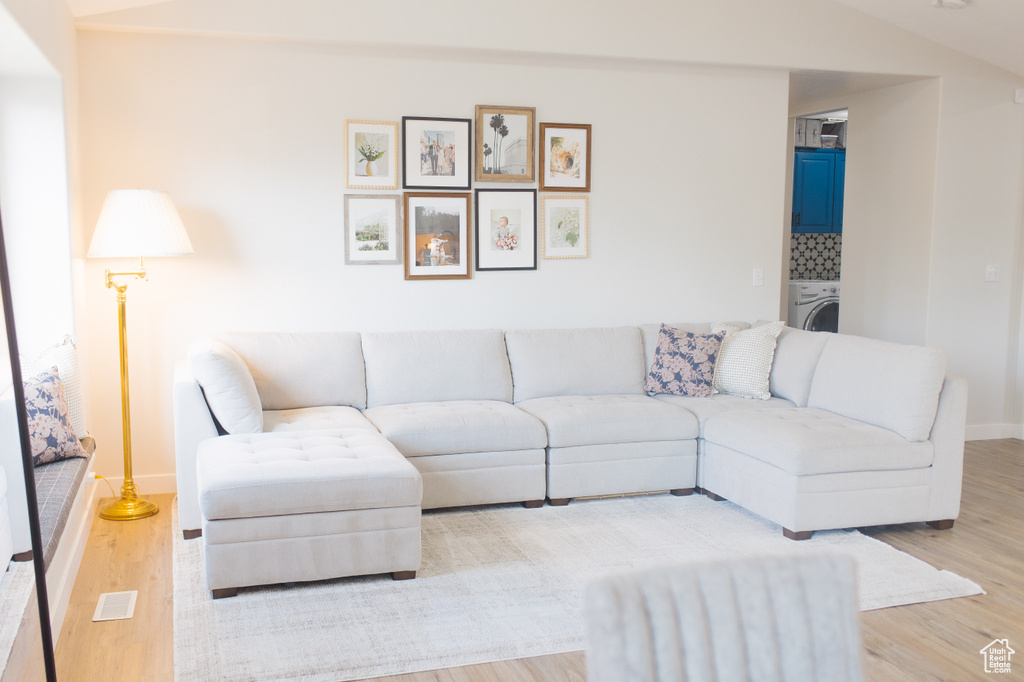 Living room with light wood-style flooring and washer / clothes dryer