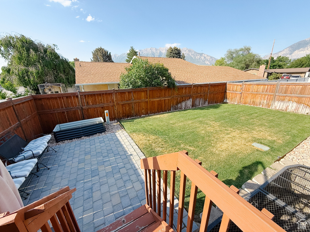 Fenced backyard featuring a patio area and a mountain view