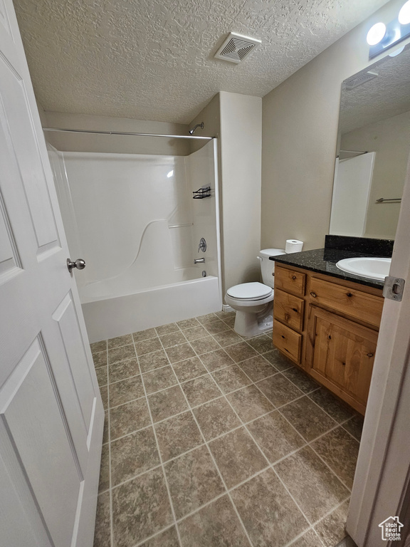 Bathroom featuring vanity, shower / tub combination, and a textured ceiling