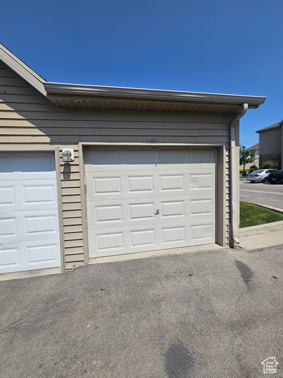 Garage featuring asphalt driveway