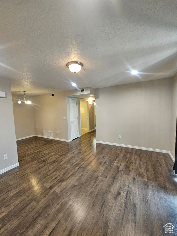 Empty room featuring a textured ceiling and wood finished floors