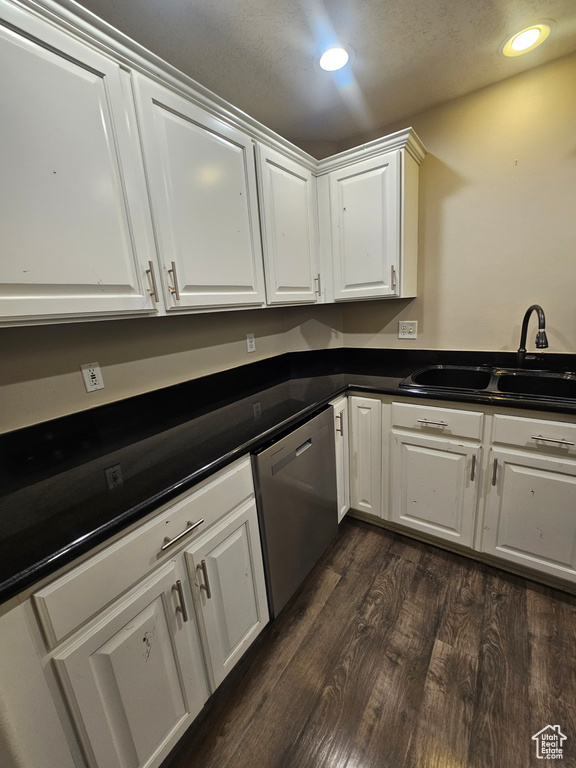 Kitchen with dishwasher, white cabinets, dark countertops, dark wood finished floors, and recessed lighting