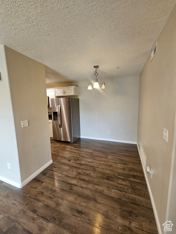 Unfurnished living room featuring dark wood-style floors and a textured ceiling