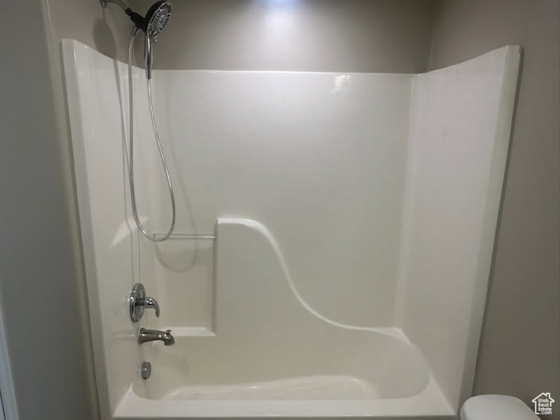 Bathroom featuring shower / tub combination and toilet