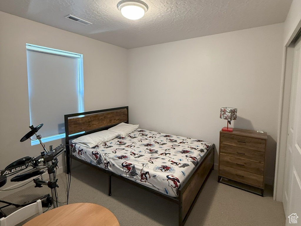 Carpeted bedroom with a textured ceiling
