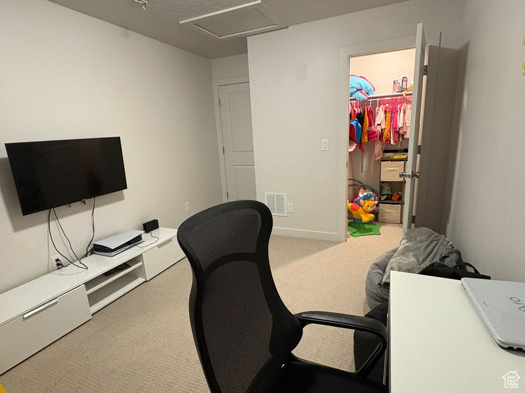 Carpeted office space featuring a textured ceiling and attic access