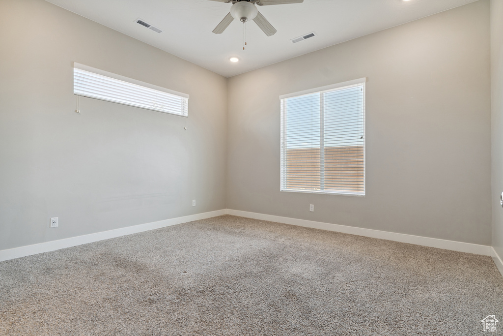 Carpeted empty room with ceiling fan and recessed lighting