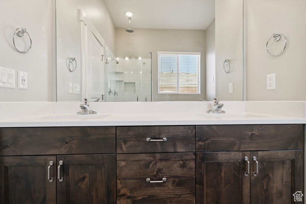 Bathroom featuring double vanity and a stall shower