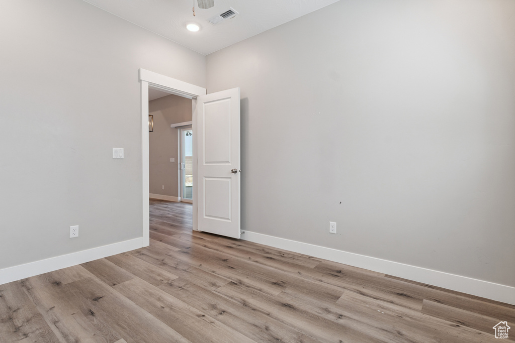 Empty room featuring light wood-style flooring and a ceiling fan
